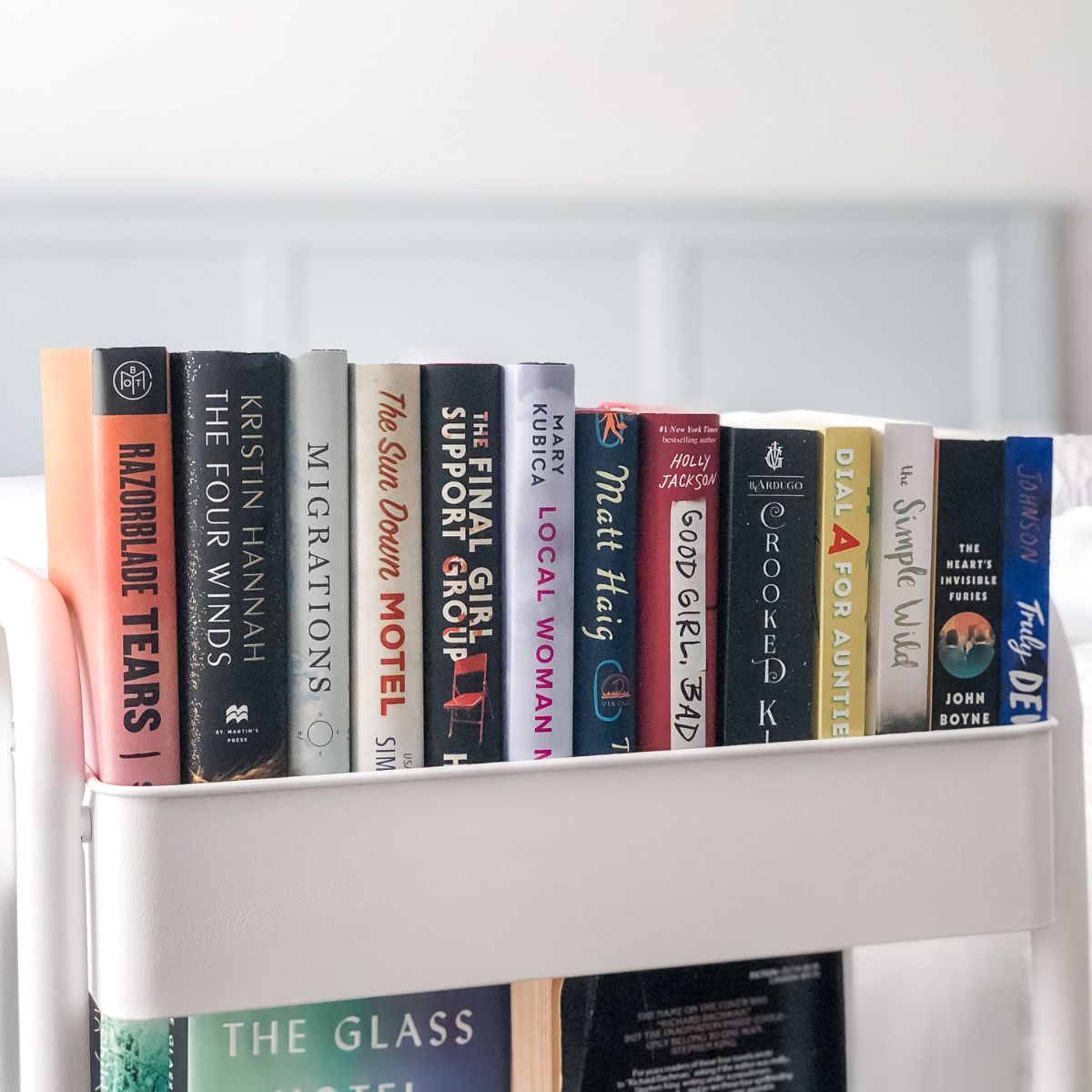 white book cart with colorful books on it