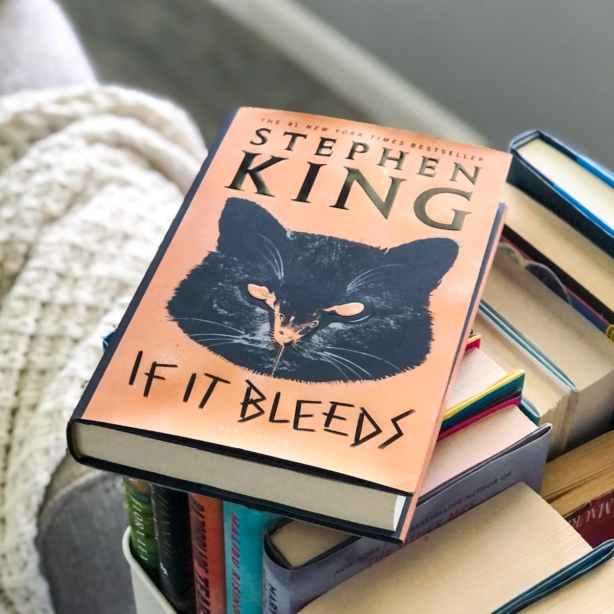 If It Bleeds by Stephen King Holly Gibney novella book cover sitting in a book cart with a white blanket behind it