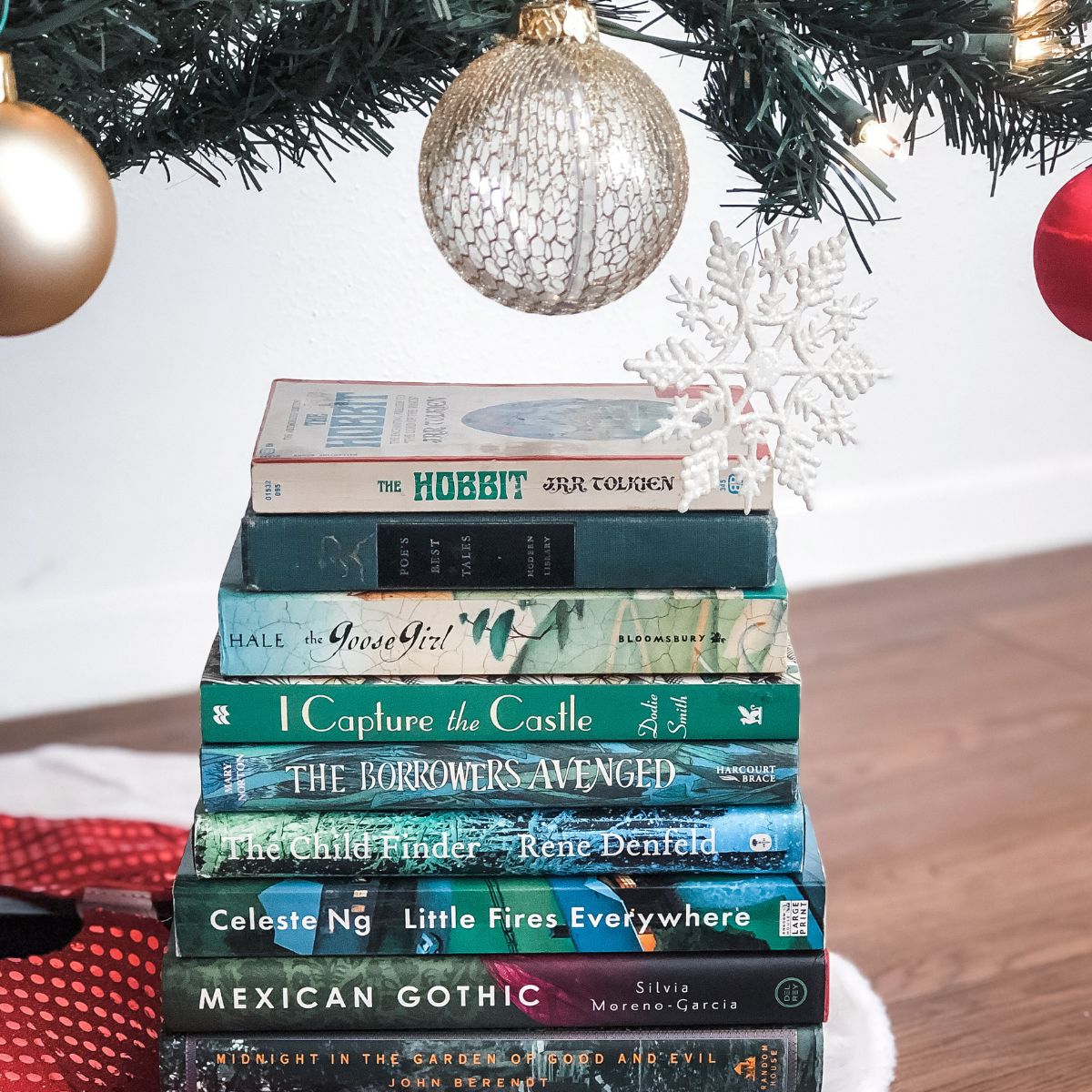 book stack next to ornaments on a Christmas tree