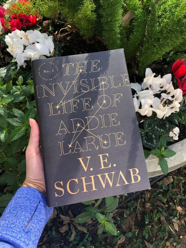 The Invisible Life of Addie Larue hardcover book in front of a flower pot