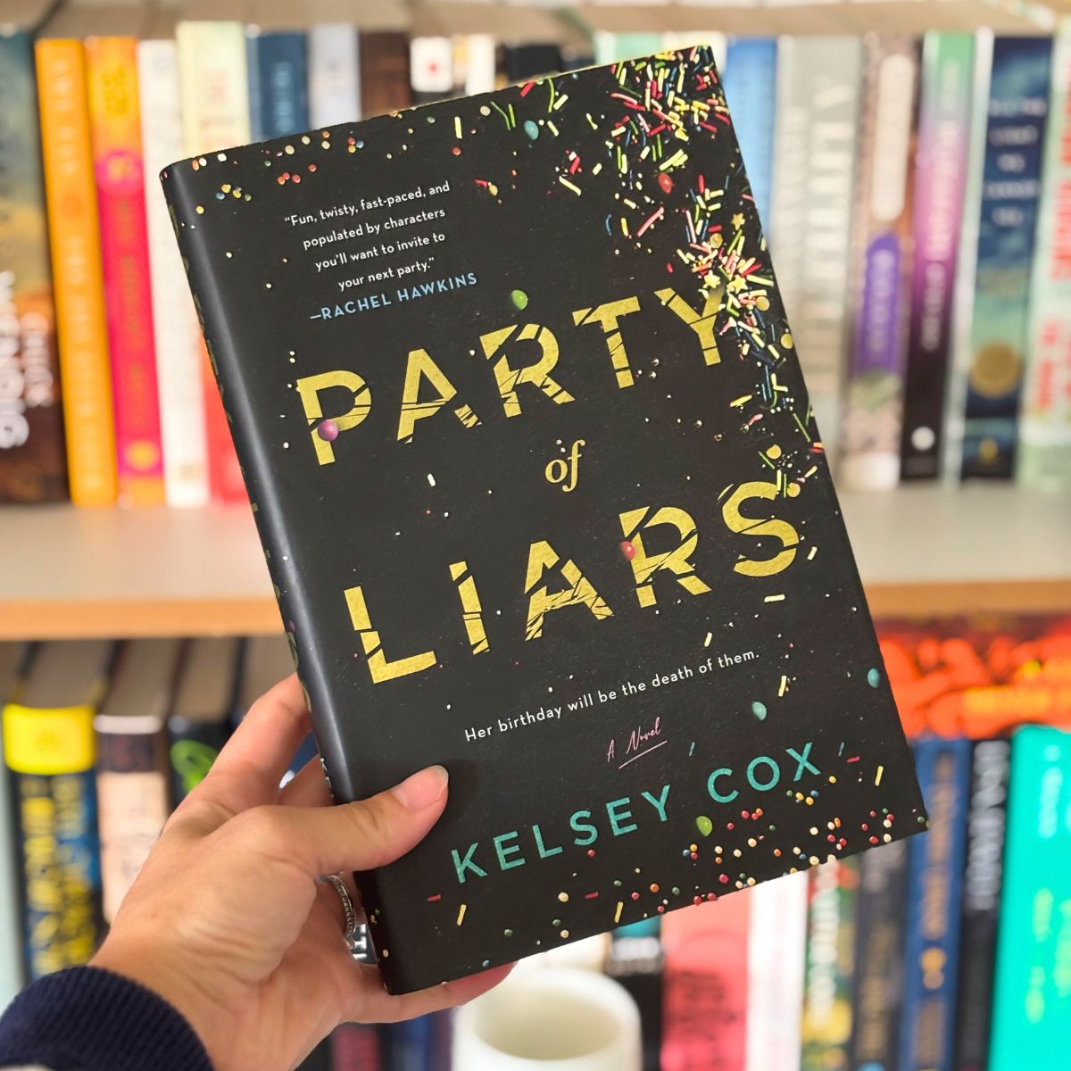 Party of Liars book cover in front of a bookshelf